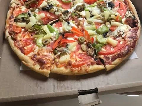A Bill's thin-crust pizza topped with tomato slices, green and red peppers, black and green olives, onion, mushrooms and pineapple, in a takeout box